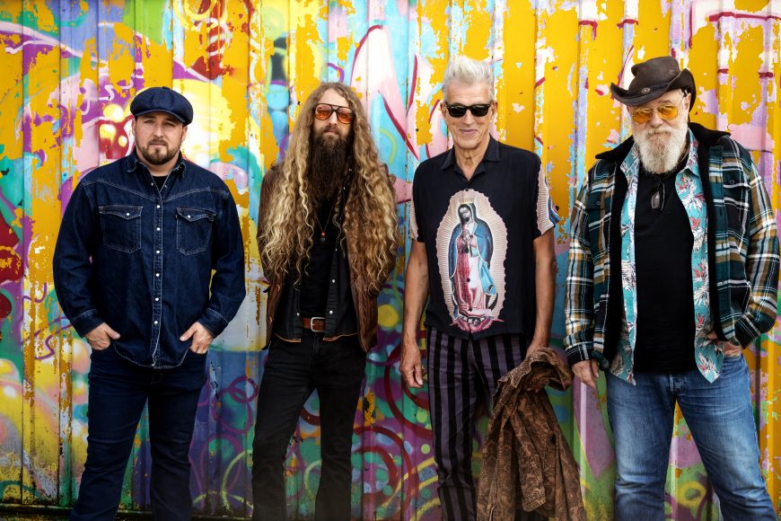 Atomic Rooster band members standing in front of colorful graffiti wall – live at The Cavern Club Liverpool, March 1st 2026